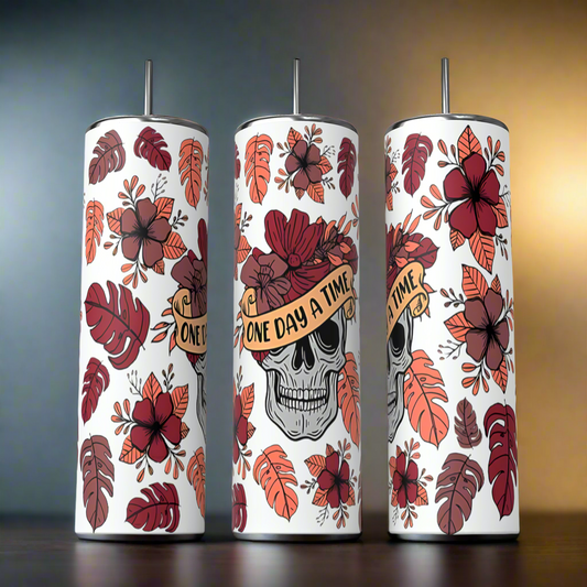 Front, side and back view of Fall skull Tumbler, featuring a skull on the front with words One day a time. Side and back of the Tumbler features a pattern of fall leaves